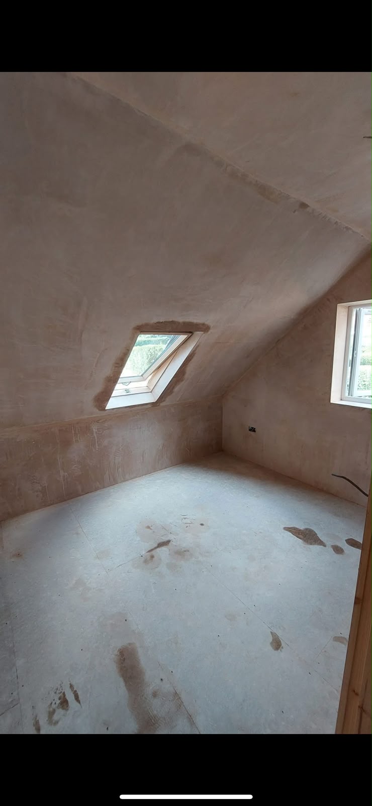 Freshly plastered loft room with skylight window
