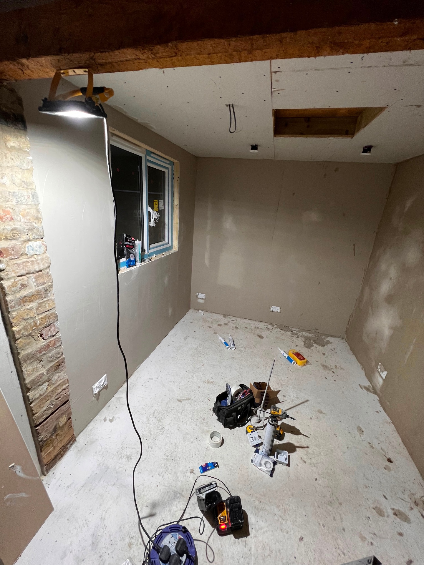 Plastered room with exposed brick reveal and new window opening