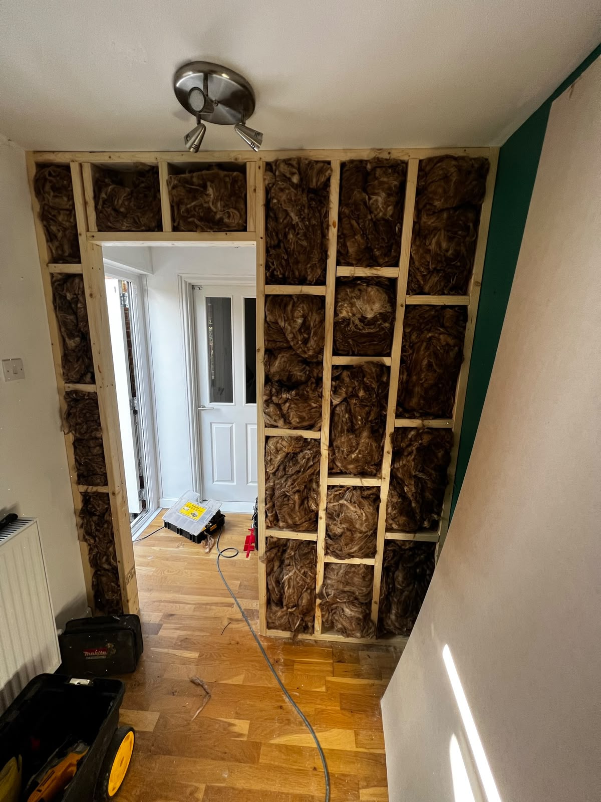 Stud wall framework with mineral wool insulation and new doorway opening