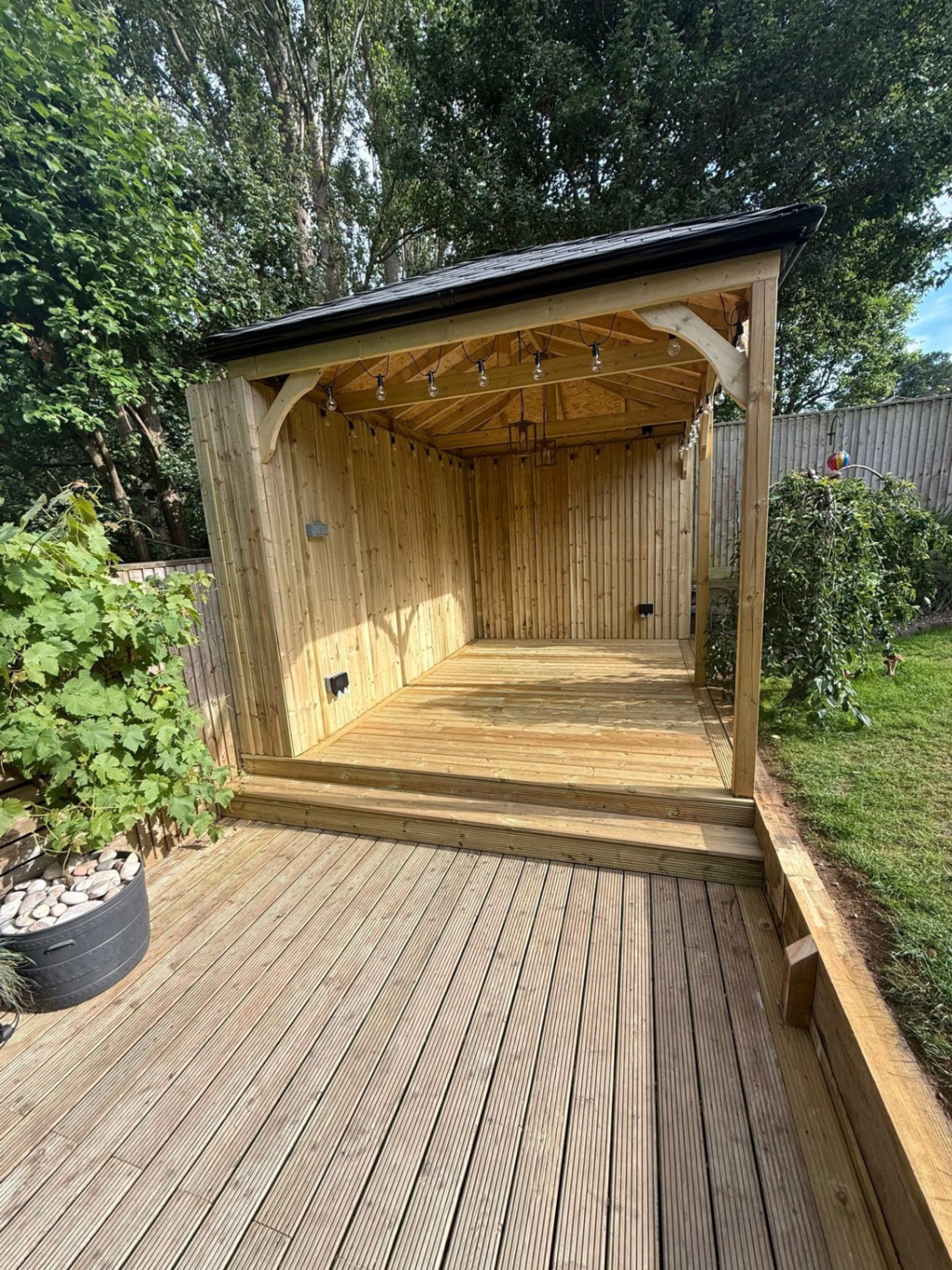 Landscaped garden with grey composite decking and slate paved border