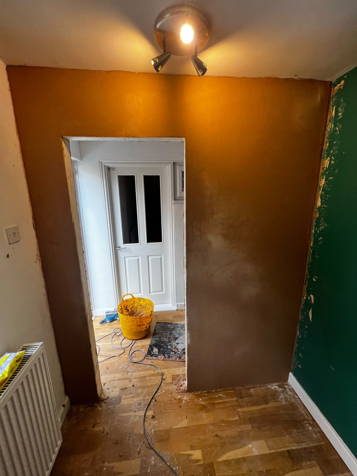 Freshly plastered hallway with new doorway opening and spotlights