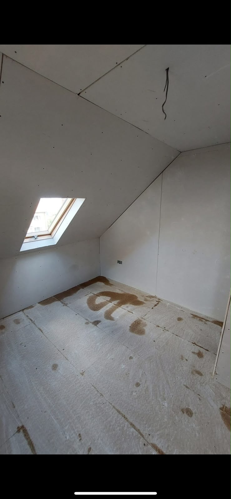 Loft conversion at plasterboard stage with Velux skylight