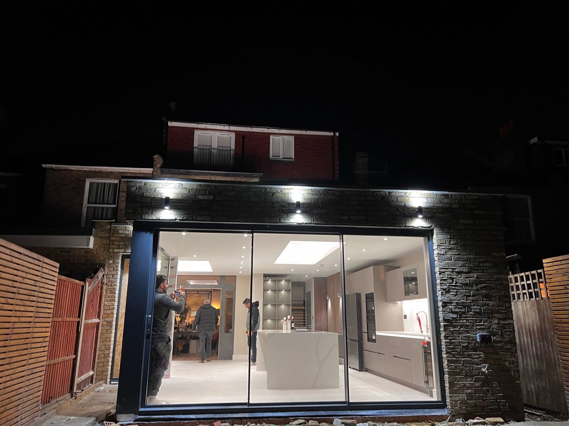 Rear kitchen extension exterior at night with bifold doors