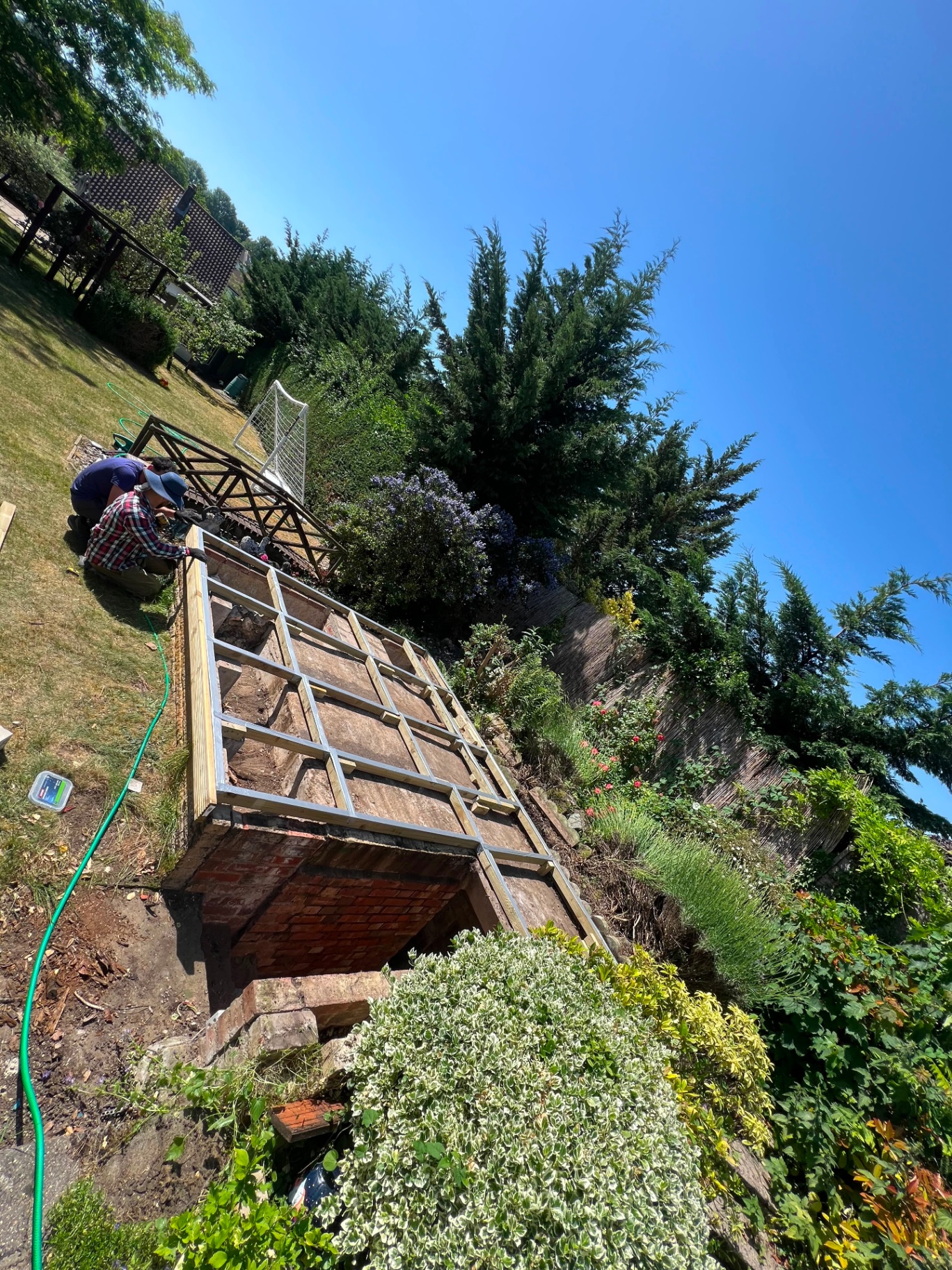 New raised terrace deck framework and joists over reclaimed brick footings